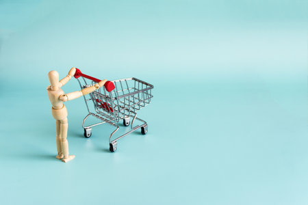 Retail and sales concept, wooden mannequin with a grocery basket.の写真素材
