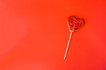 A red lollipop on a red background of a copy space.の写真素材
