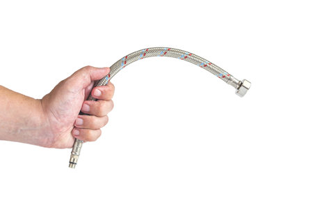 The hand holds the hose of the flexible tap liner. Hoses for a mixer in close-up on a white background isolateの写真素材
