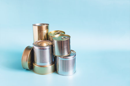 Tin cans with food in close-up on a colored background. Long-term storage products.の写真素材