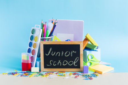 A large set of school supplies and an inscription on the board "Junior school"の写真素材