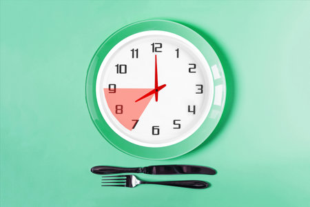 The clock shows eight o'clock in the morning, breakfast time. Clock face close-up on a light backgroundの写真素材