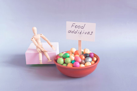 A cup with various colored food additives and inscriptions on the plates in close-up on a light background.の写真素材