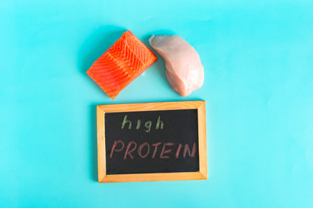 Foods with a high protein content and the corresponding inscription in colored letters on a dark boardの写真素材