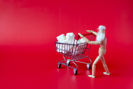 A man with a basket filled with cubes of sweet sugar, close-up on a red backgroundの写真素材