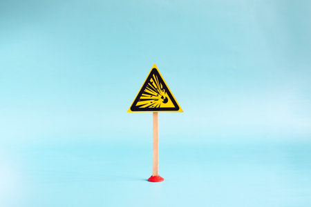 Yellow triangular sign with flying stones close-up on a white backgroundの写真素材