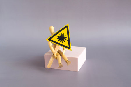 A warning sign radiation in the hands of a mannequin sitting on a podium in close-up.