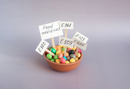 Dishes filled with various food additives and information signs, close-up on a light background.