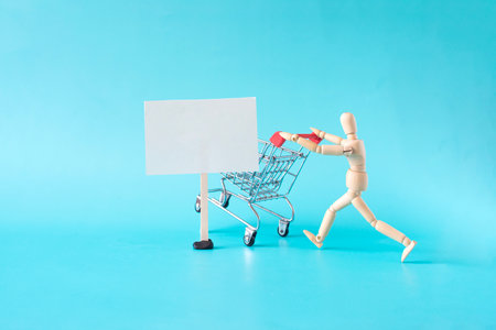 A man runs with an empty grocery cart on a light background next to a white banner for textの写真素材