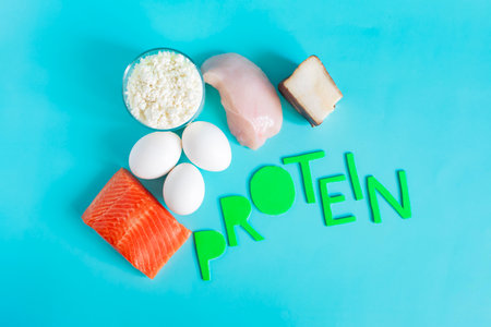 A set of high-protein foods with the word "Protein" written in colored letters on a light backgroundの写真素材