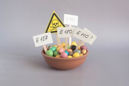 Dishes with colored food additives and a close-up warning sign on a light background. Warning about the dangers of uncontrolled use of dietary supplementsの写真素材
