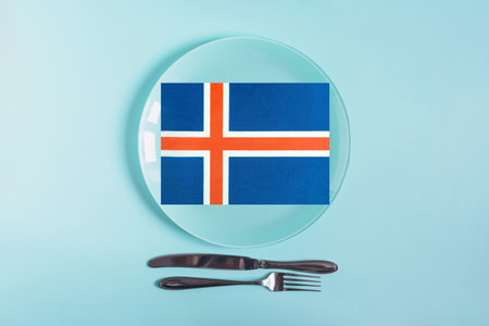A light plate with appliances, inside of which the flag of Iceland is depicted in close-up. The cuisine of Icelandの写真素材