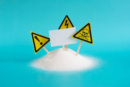 Health warning signs on the background of a mountain of granulated sugar and an empty close-up sign on a light backgroundの写真素材