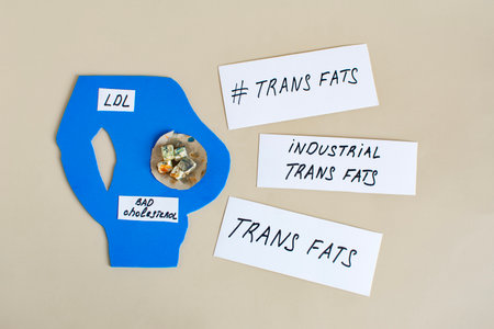 A silhouette of a man with a large belly, inside which are placed various trans fats and the words "trans fats"の写真素材
