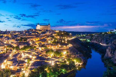 View of Toledo, Spain including Alcazar and the cathedral at dusk.