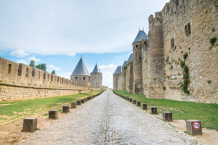 Walk way road in Ancient castle Carcassonne. Ancient fortress with towers and blue sky with clouds in background. Languedoc, France, Europe.のeditorial素材