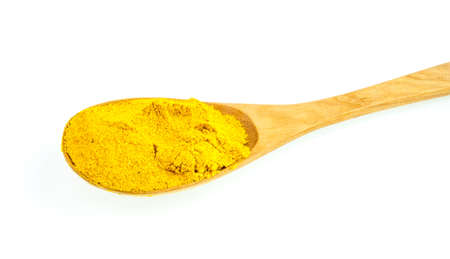 curry powder in a wooden spoon on a white background.の写真素材