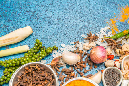 Variety of spices and herbs in a cup and spoon on a wooden background.の写真素材
