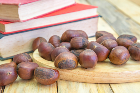 Delicious roasted chestnuts on wood backgroundの写真素材