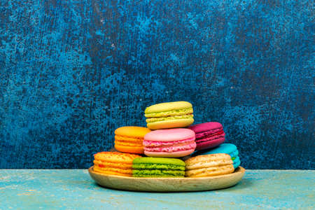 Colorful macarons on vintage pastel background. Macaron or Macaroon is sweet meringue-based confection.の写真素材