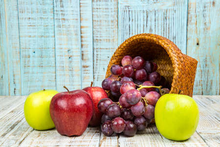 fresh apples with red grapes on wood backgroundの写真素材