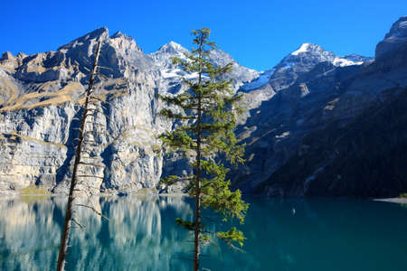 Oeschinensee lake in Kandersteg, Switzerland. Panoramic view of the mountains and azure water on a clear sunny summer day. Popular tourist attraction.の写真素材