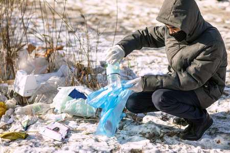 volunteer collects garbage in a bag on the street, the concept of environmental protectionの写真素材