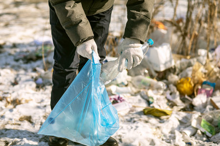 Volunteer hands with plastic garbage, the concept of planetary pollution and environmental disasterの写真素材