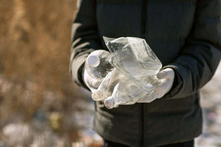 Volunteer hands with plastic garbage, the concept of planetary pollution and environmental disasterの写真素材