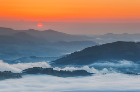 Ukraine. Carpathians. Morning fog in the valley village Dzembronの写真素材