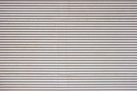Weathered painted corrugated metal sheet texture backgroundの写真素材