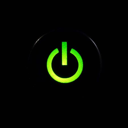 Glowing power button on black backgroundの写真素材