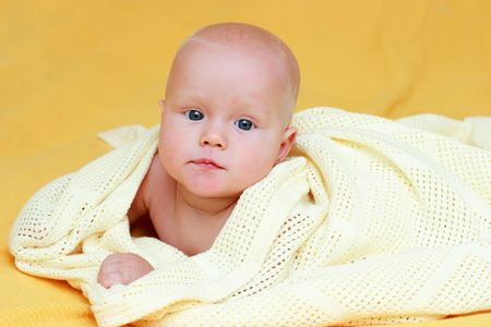 Seven month baby wrapped in a blanketの写真素材