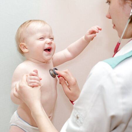 Children's doctor exams infant with stethoscopeの写真素材