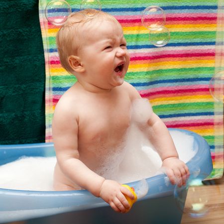 Little baby girl bathing with soap bubbles