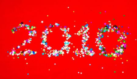 Star confetti in the shape of number 2010 on red backgroundの写真素材