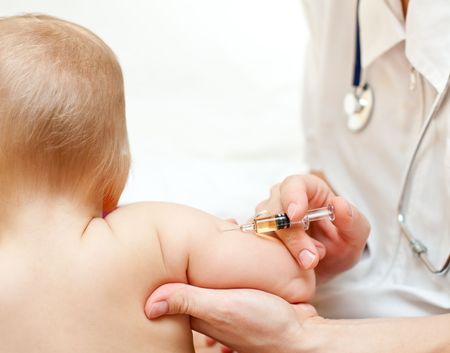 Doctor giving a child an intramuscular injection in arm, shallow DOFの写真素材