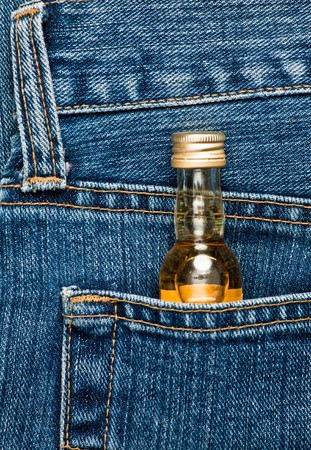 Blue jeans pocket with small bottle of alcoholの写真素材