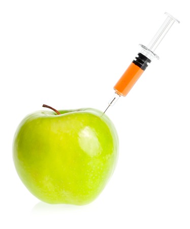 Genetic modification concept with green apple receiving an injectionの写真素材