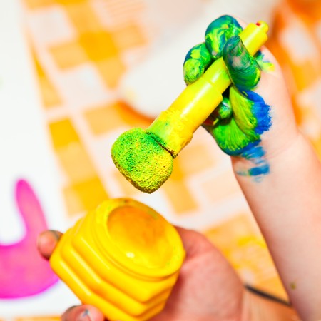 Child holding finger paint brush close-upの写真素材