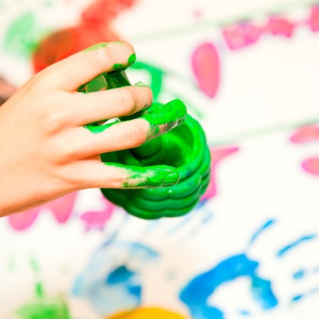 Child holding finger paint brush close-upの写真素材