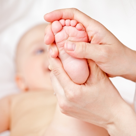 Masseur massaging little baby's foot, shallow focusの写真素材