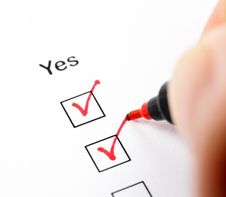 Hand with pen marks the check box Yesの写真素材