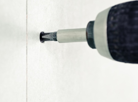 Driving a screw into drywallの写真素材