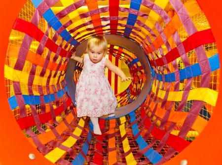 Little girl playing in a tunnel of maze playgroundの写真素材