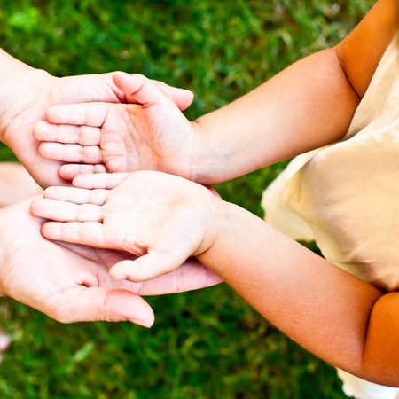 Little girl showing her hands to mother outdoorsの写真素材