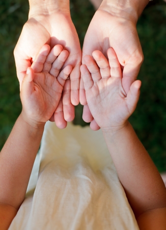 Little girl showing her hands to mother outdoorsの写真素材