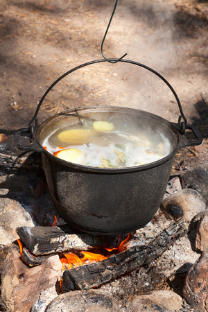 Cooking fish soup on camping bonfireの写真素材