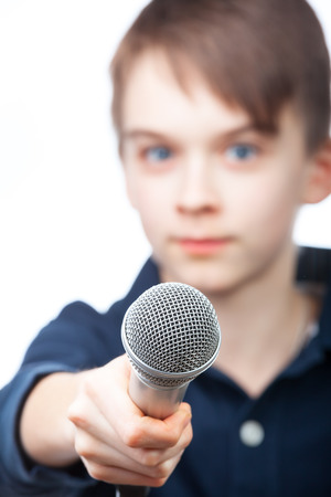 Boy holding microphone, fucus on micの写真素材