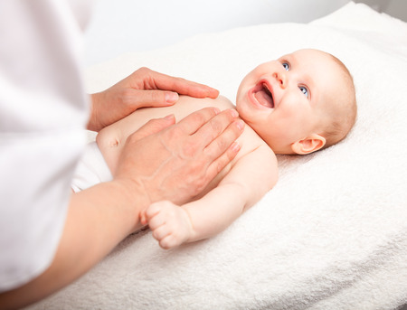 Three month baby girl is receiving chest massage from a female massage therapist Three month baby girl is receiving chest massage from a female massage therapist